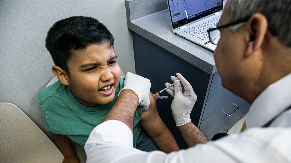 Boy receives covid shot from pediatrician