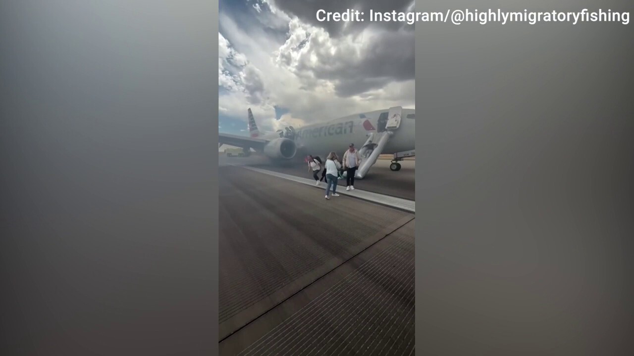 Passengers evacuate an American Airlines aircraft after a landing gear issue on the runway at Denver International Airport. (Credit: Instagram / @highlymigratoryfishing)