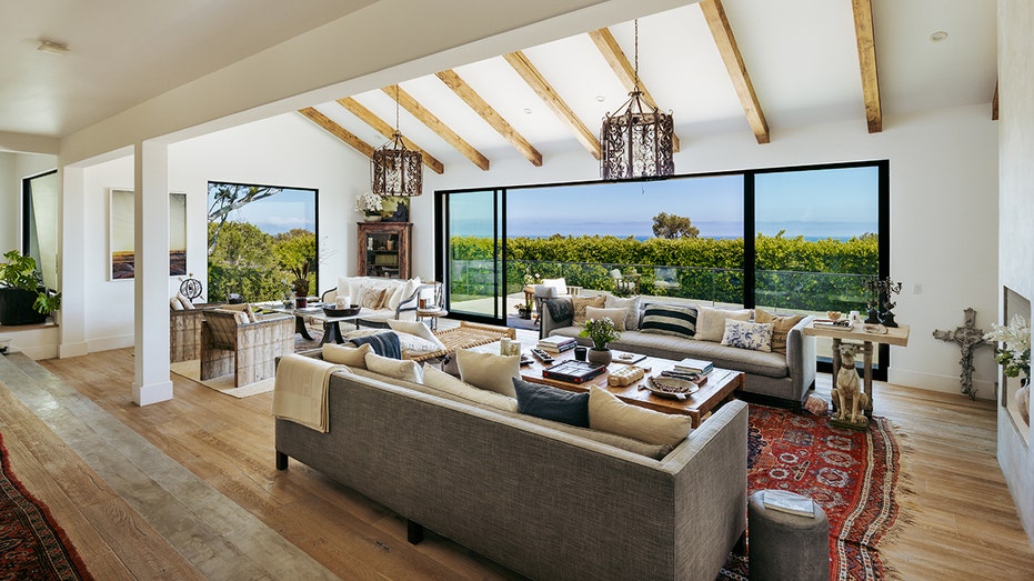 The living room features wooden beams and floor-to-ceiling sliding glass doors.