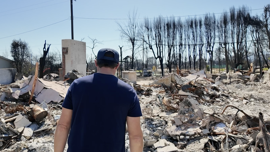 A man walks among his burnt house